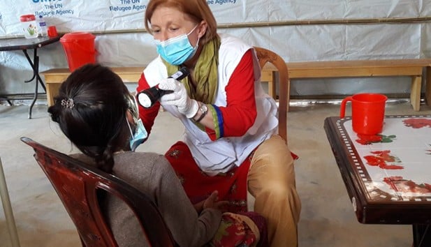 lege undersøker pasient under primitive forhold