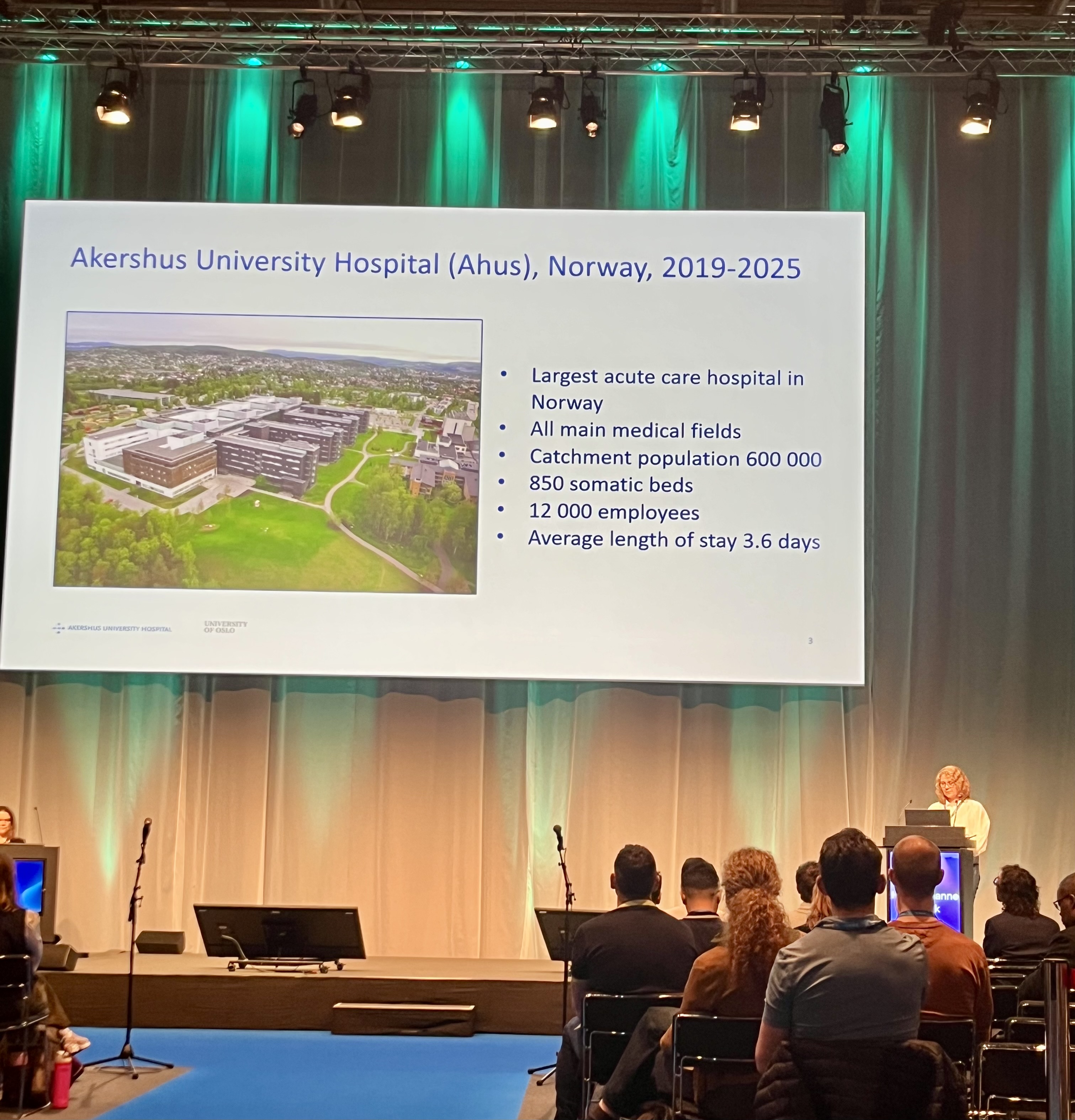 En gruppe mennesker som sitter foran en projektorskjerm