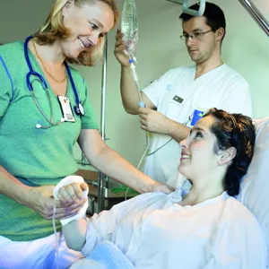 Doktor sykepleier og pasient i seng på sykehus