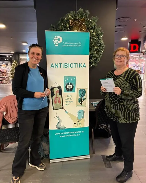 Et par kvinner som står ved en plakat